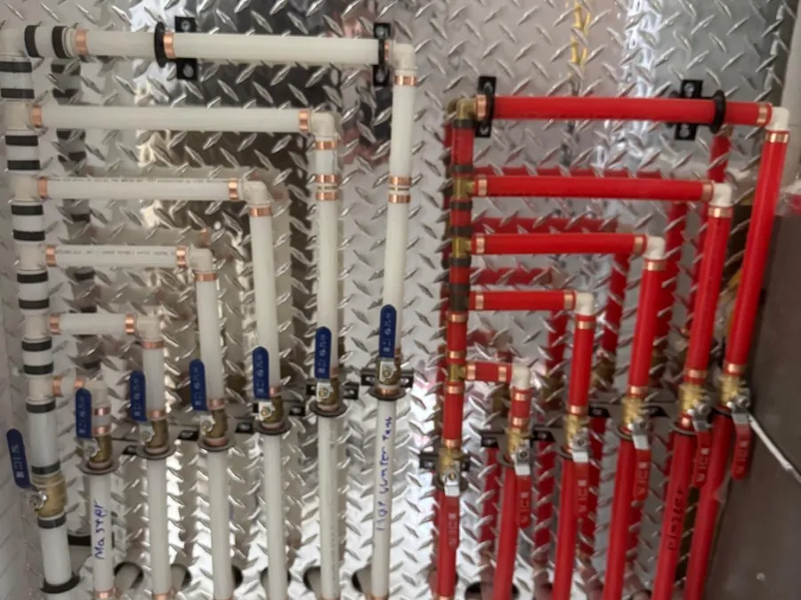 A PEX manifold with labelled shut off valves installed by A1 Plumbing.