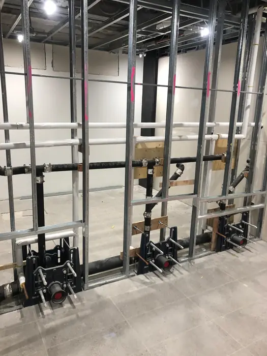 Cast iron stacks braced and clamped on a commercial fit out.