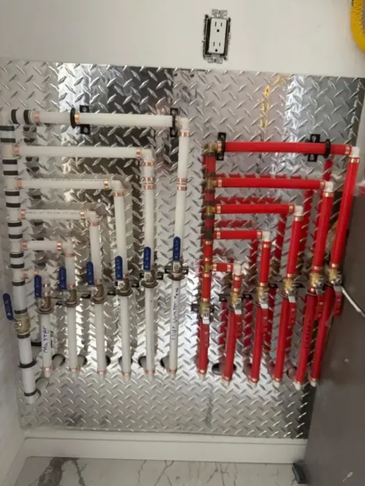 A PEX manifold with labelled shut off valves.