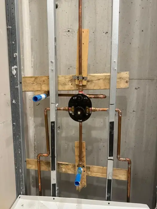 A shower valve set and piped before the wall goes on.