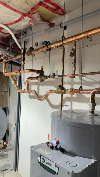 Copper pipework above a tank water heater.